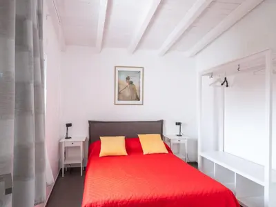 a bedroom with a red bed with two yellow pillows at Villa Timpi Rossi Total Relax in Alcamo