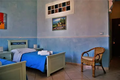 a bedroom with a bed and a chair at B&B Oleaster - Bolognetta in Bolognetta