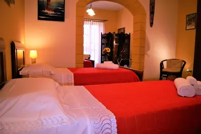 a hotel room with two beds with red sheets at B&B Oleaster - Bolognetta in Bolognetta