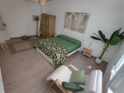 a bedroom with a green bed and a chair at L'Arco Verde San Nicola l'Arena in Trabia