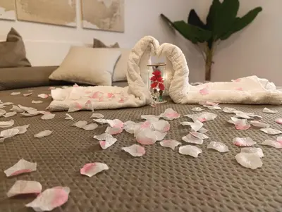 a table with pink petals on the floor with a towel and a swan at L'Arco Verde San Nicola l'Arena in Trabia