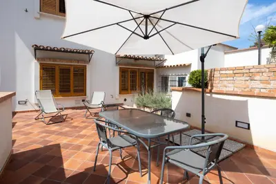 a patio with a table and chairs and an umbrella at Casa Ibiscus in Mondello