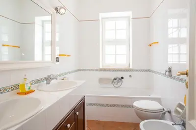 a bathroom with two sinks and a tub and a toilet at Casa Ibiscus in Mondello
