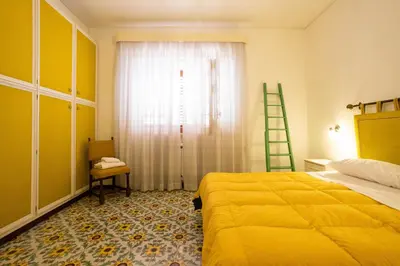 a bedroom with a bed and a window with a ladder at Casa Ibiscus in Mondello