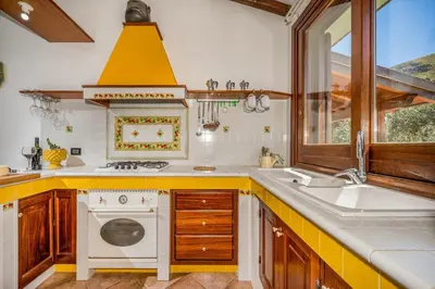 a kitchen with a sink and a stove at Villa Miceli con piscina privata in Scopello