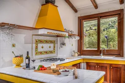 a kitchen with a stove and a yellow hood at Villa Miceli con piscina privata in Scopello