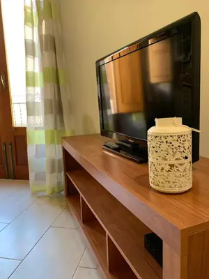 a flat screen tv sitting on top of a wooden entertainment center at Appartamento Casa Trento in Castellammare del Golfo