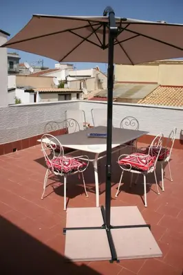 a table and chairs with an umbrella on a roof at Casa Bellini in Palermo