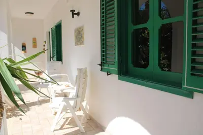 a courtyard of a house with white walls and green shutters at Da Silvia, a due passi dal mare in San Vito lo Capo