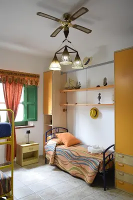 a small bedroom with a bed with orange sheets at Da Silvia, a due passi dal mare in San Vito lo Capo