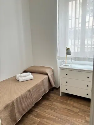 a bedroom with a bed and a dresser and a window at Come fossi a casa in Palermo