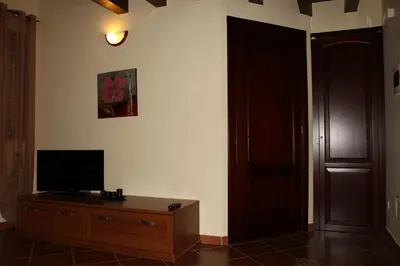 a living room with a television on a wooden dresser at Villa Cattleya in Campofelice di Roccella