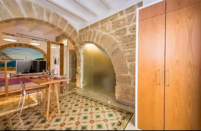 a home office with a wooden desk and a stone wall at Casa Rosa Castellammare del Golfo in Castellammare del Golfo