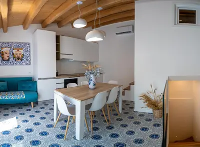 a kitchen and dining room with a table and chairs at Casa Rosa Castellammare del Golfo in Castellammare del Golfo