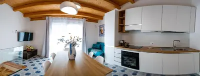 a kitchen and dining room with a wooden table at Casa Rosa Castellammare del Golfo in Castellammare del Golfo