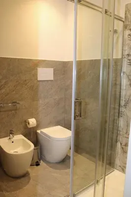 a bathroom with a toilet and a sink and a shower at ALLUMARO HOUSE in Castellammare del Golfo