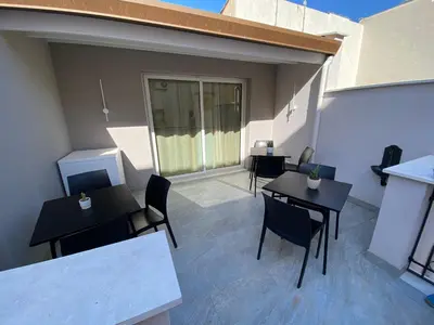 a patio with tables and chairs on a building at ALLUMARO HOUSE in Castellammare del Golfo