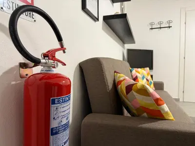 a fire extinguisher next to a couch with a fire hydrant at A CASA DI IDA in Palermo