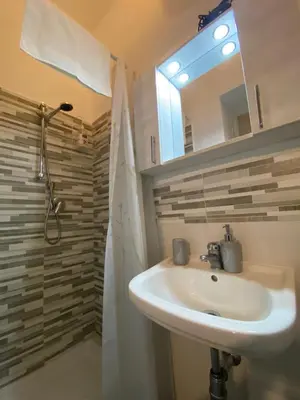 a bathroom with a sink and a shower with a mirror at A CASA DI IDA in Palermo