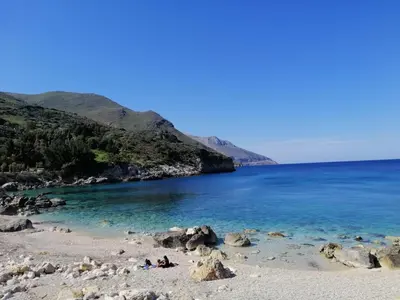 a group of people laying on a beach near the water at Villa Chifeci Scopello - Appartamento Rosso in Scopello