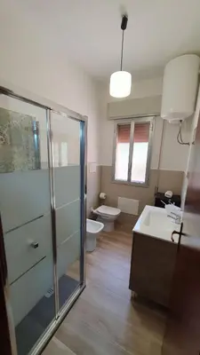 a bathroom with a shower and a toilet and a sink at Villa Chifeci Scopello - Appartamento Rosso in Scopello