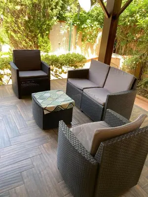 a patio with wicker chairs and a table and a couch at Villa Chifeci Scopello - Appartamento Verde in Scopello