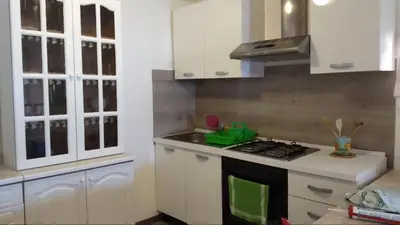 a kitchen with white cabinets and a stove top oven at Villa Chifeci Scopello - Appartamento Verde in Scopello