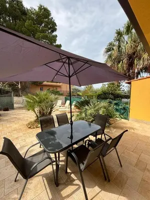 a table and chairs with an umbrella on a patio at Villa Chifeci Scopello - Appartamento La Zàgara in Scopello