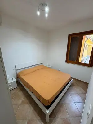 a bedroom with a bed in a room with a window at Villa Chifeci Scopello - Appartamento La Zàgara in Scopello