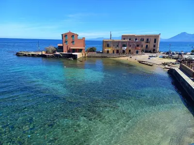a large body of water with buildings on a beach at L'Aurora in Porticello