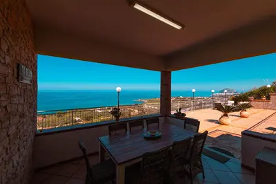 a balcony with a table and a view of the ocean at Villa Le Terrazze in Cefalù