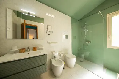 a bathroom with a toilet and a sink and a shower at Villa Le Terrazze in Cefalù