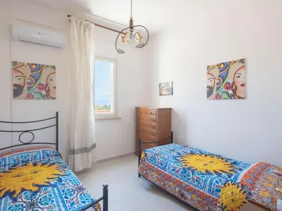 a bedroom with two beds and a dresser and a window at [Baia di Guidaloca] Villino Scopello Free Parking in Scopello