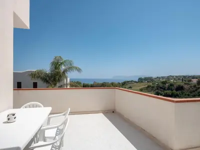 a balcony with a table and chairs and a view at [Baia di Guidaloca] Villino Scopello Free Parking in Scopello