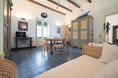 a living room with a table and a dining room at Casetta Bianca Sant'Elia in Porticello