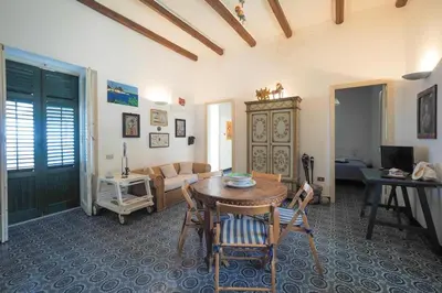 a living room with a table and chairs and a couch at Casetta Bianca Sant'Elia in Porticello