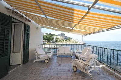 a patio with chairs and a table and the ocean at Casetta Bianca Sant'Elia in Porticello