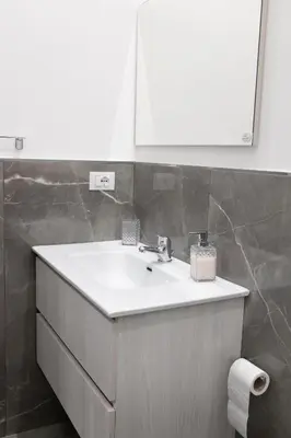 a bathroom with a white sink and a mirror at Casa Gaia in Terrasini
