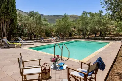 a swimming pool with chairs and a table and a tablektop at Villa Giovanna con Piscina by Wonderful Italy in Castellammare del Golfo