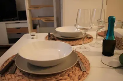 a table with two plates and wine glasses on it at Porta delle Stelle Vucciria in Palermo