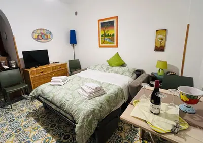 a bedroom with a bed and a table with a bottle of wine at Casa a Mare La Stalletta in Palermo