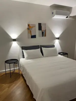 a bedroom with a large white bed with two lamps at Baaria house in Bagheria