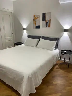 a bedroom with a large white bed with two lamps at Baaria house in Bagheria