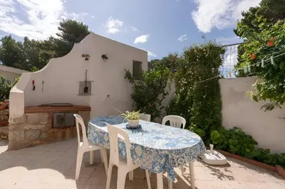 a table and chairs on a patio in front of a house at Casa Vacanze Maria in San Vito lo Capo