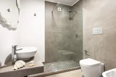 a bathroom with a shower and a toilet and a sink at Mille e Una Notte By Domus Sicily in Mondello