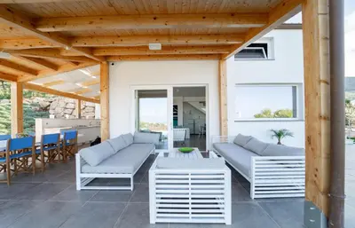 a patio with two couches and a table and chairs at Villa Majestatis con piscina privata in Scopello