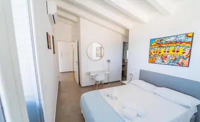 a white bedroom with a bed and a mirror at Villa Majestatis con piscina privata in Scopello
