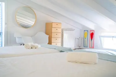 a white bedroom with two beds and a mirror at Villa Majestatis con piscina privata in Scopello