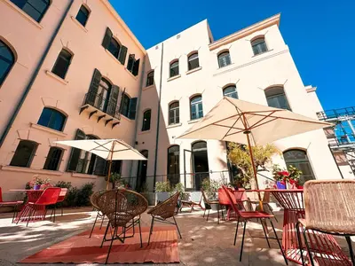 a patio with chairs and umbrellas in front of a building at Ostello Bello Palermo in Palermo