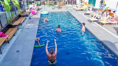 a group of people swimming in a swimming pool at Ostello Bello Palermo in Palermo